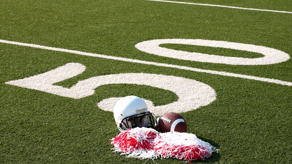 American football helmet on the fifty yard line of the field.