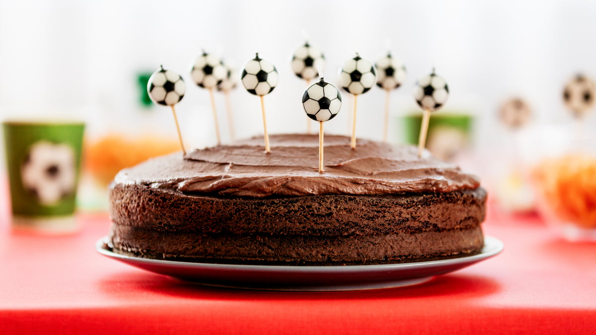 Chocolate birthday cake with soccer ball decorations.