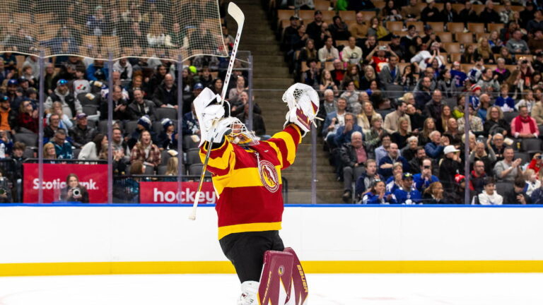 Henrik Lundqvist celebrates on the ice during a hockey legends game.