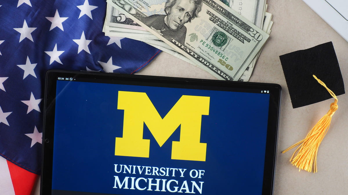 Tablet reading University of Michigan next to a US flag and dollars.
