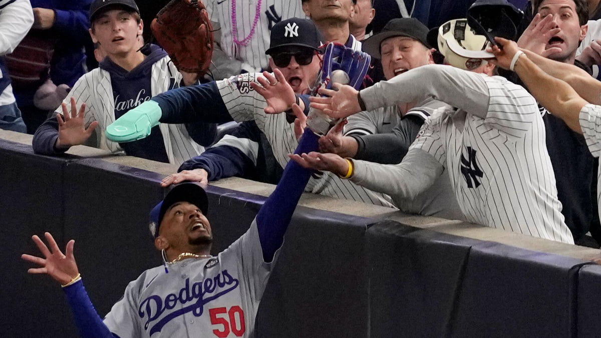 New York Yankees try to prevent a Dodgers outfielder from making a catch during the 2024 World Series.
