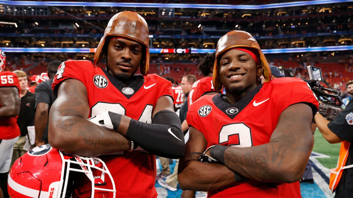 Georgia Bulldogs players wearing old-style leather football helmets.