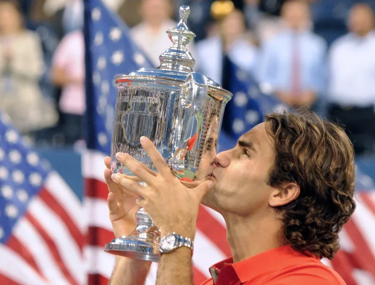 Roger Federer kisses the US Open trophy after winning it for the fifth consecutive time.