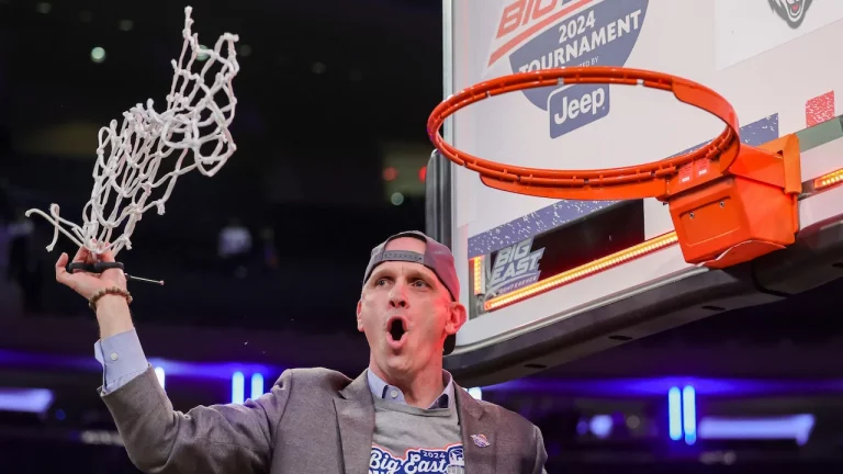 Dan Hurley cutting down the net after UConn won the 2023-24 Big East NCAAM Tournament.