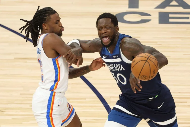 Minnesota Timberwolves forward Julius Randle dribbles the ball past the Oklahoma City Thunder's Cason Wallace in Game 3 of the 2025 NBA Western Conference Finals.